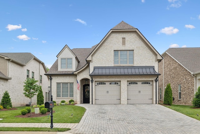 2143 White Poplar Ct, Murfreesboro, TN 37130 - french country style house featuring an attached garage, brick siding, decorative driveway, and a front lawn