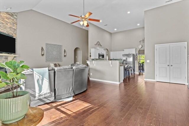 7211 Deervalley Dr, Fairview, TN 37062 - living room with high vaulted ceiling, ceiling fan, arched walkways, dark wood-style flooring, and baseboards
