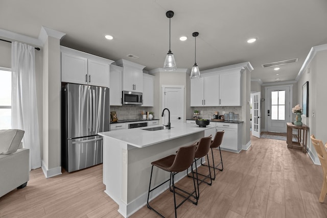 2507H Strong St, Columbia, TN 38401 - kitchen with appliances with stainless steel finishes, a sink, ornamental molding, decorative backsplash, and light wood-style flooring