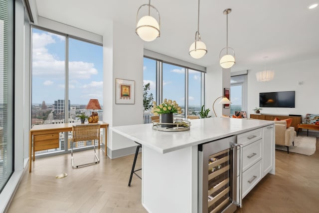 1616 W End Ave Unit 2008, Nashville, TN 37203 - kitchen featuring wine cooler, white cabinetry, plenty of natural light, open floor plan, and a wall of windows