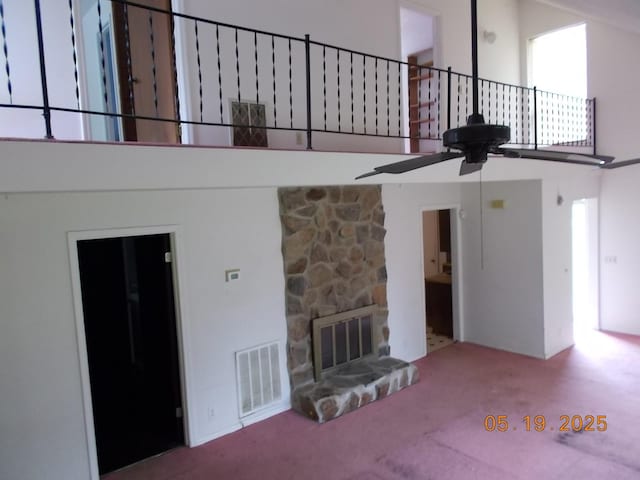 4064 Elizabeth Dr, Hermitage, TN 37076 - unfurnished living room with a towering ceiling, ceiling fan, carpet flooring, and a stone fireplace