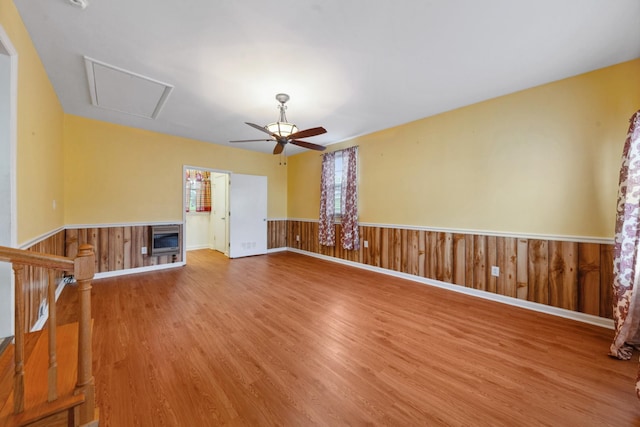 206 Crestland Dr, Columbia, TN 38401 - unfurnished living room featuring a ceiling fan, wood finished floors, a wainscoted wall, heating unit, and attic access