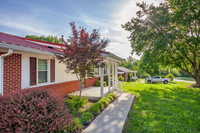 206 Crestland Dr, Columbia, TN 38401 - view of side of home featuring brick siding, a lawn, covered porch, and metal roof