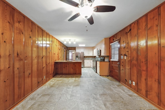 206 Crestland Dr, Columbia, TN 38401 - kitchen featuring stainless steel appliances, a peninsula, wood walls, ceiling fan, and brown cabinetry