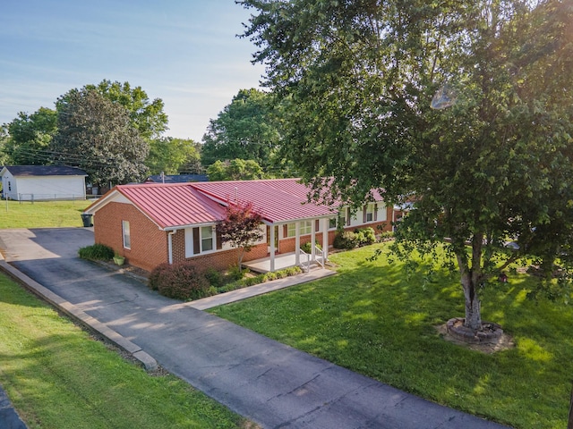 206 Crestland Dr, Columbia, TN 38401 - view of front facade featuring a standing seam roof, brick siding, metal roof, a front lawn, and asphalt driveway