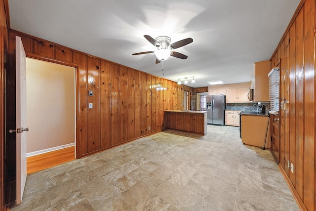 206 Crestland Dr, Columbia, TN 38401 - kitchen featuring stainless steel refrigerator with ice dispenser, a peninsula, a ceiling fan, wood walls, and a sink