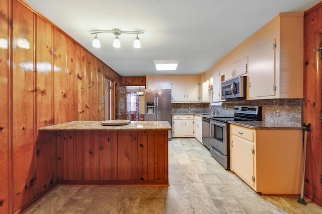 206 Crestland Dr, Columbia, TN 38401 - kitchen featuring stainless steel appliances, a peninsula, a sink, tasteful backsplash, and white cabinets