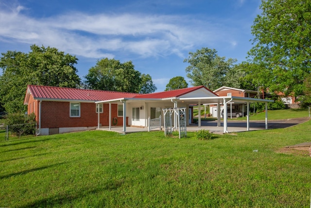 206 Crestland Dr, Columbia, TN 38401 - back of property featuring a lawn, metal roof, brick siding, and an attached carport