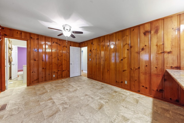 206 Crestland Dr, Columbia, TN 38401 - unfurnished bedroom with wood walls, ensuite bathroom, tile patterned floors, and ceiling fan