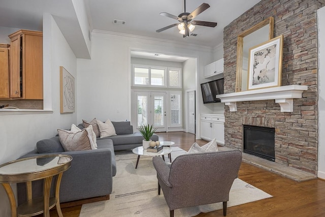 960 Caldwell Ln, Nashville, TN 37204 - living room featuring a ceiling fan, a stone fireplace, wood finished floors, and crown molding