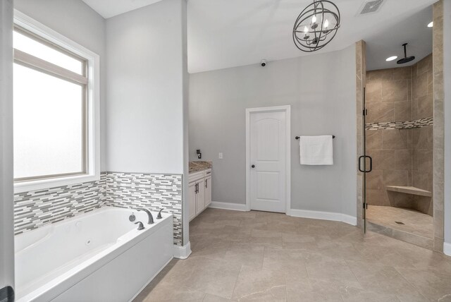 1161 Reda Dr, Clarksville, TN 37042 - full bath featuring a stall shower, a garden tub, vanity, a chandelier, and baseboards