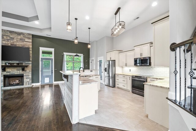 1161 Reda Dr, Clarksville, TN 37042 - kitchen featuring stainless steel appliances, backsplash, light stone countertops, pendant lighting, and a kitchen island with sink