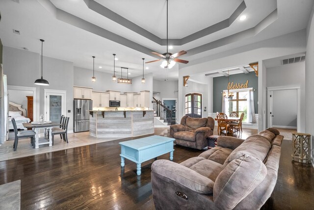 1161 Reda Dr, Clarksville, TN 37042 - living room featuring stairway, a high ceiling, a tray ceiling, wood finished floors, and recessed lighting