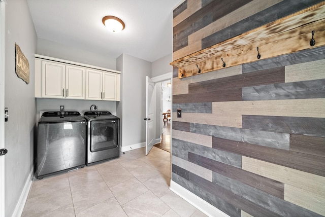1161 Reda Dr, Clarksville, TN 37042 - washroom with washing machine and dryer, cabinet space, baseboards, wooden walls, and light tile patterned floors