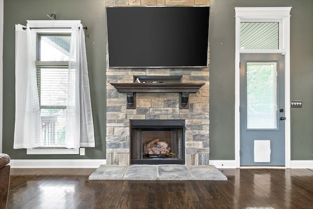 1161 Reda Dr, Clarksville, TN 37042 - unfurnished living room featuring baseboards, wood finished floors, a stone fireplace, and healthy amount of natural light