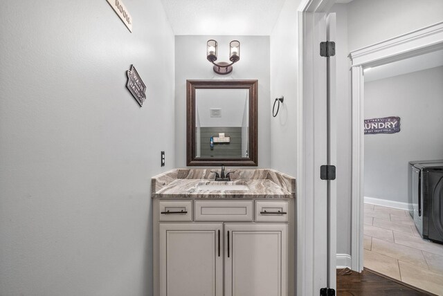 1161 Reda Dr, Clarksville, TN 37042 - bathroom with washer and dryer, vanity, baseboards, and wood finished floors