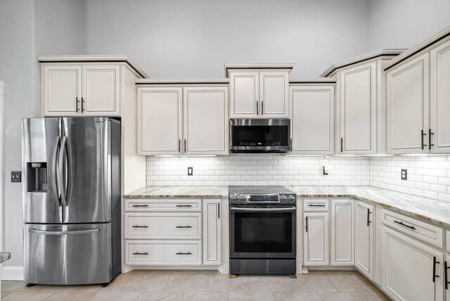 1161 Reda Dr, Clarksville, TN 37042 - kitchen featuring stainless steel appliances, backsplash, light stone counters, and light tile patterned floors