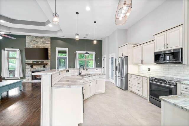 1161 Reda Dr, Clarksville, TN 37042 - kitchen featuring appliances with stainless steel finishes, a sink, decorative backsplash, a large island, and white cabinetry