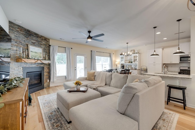 979 Carnation Dr, Spring Hill, TN 37174 - living area with a stone fireplace, ceiling fan, a chandelier, light wood-type flooring, and recessed lighting