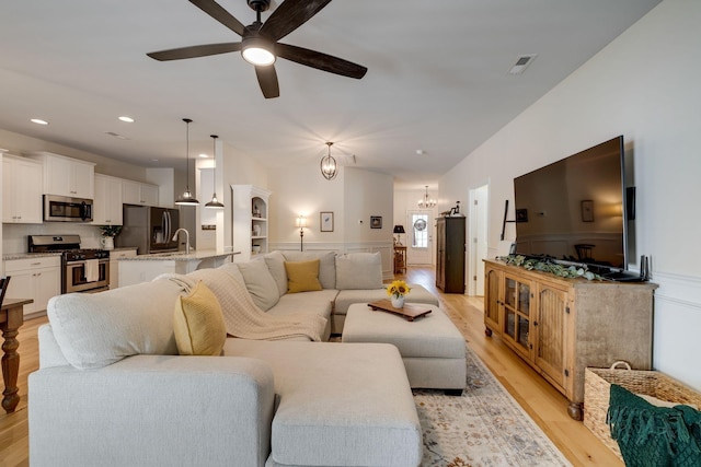 979 Carnation Dr, Spring Hill, TN 37174 - living room with a ceiling fan, light wood-style floors, a wainscoted wall, recessed lighting, and a decorative wall