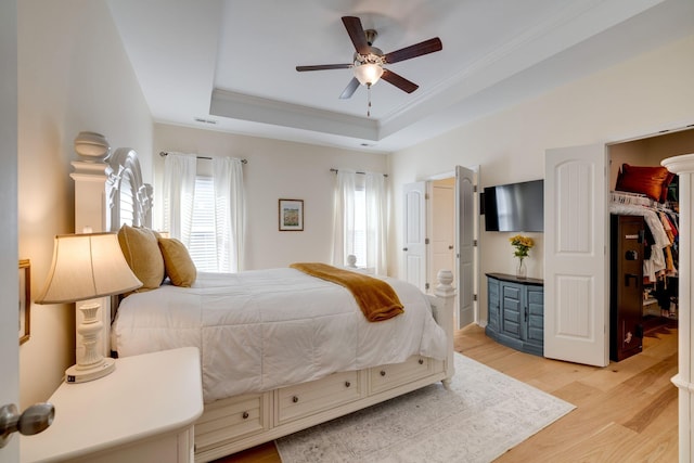 979 Carnation Dr, Spring Hill, TN 37174 - bedroom featuring a raised ceiling, light wood-style floors, a walk in closet, crown molding, and connected bathroom