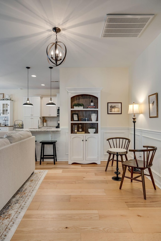 979 Carnation Dr, Spring Hill, TN 37174 - living room with a wainscoted wall, light wood-type flooring, recessed lighting, and a chandelier