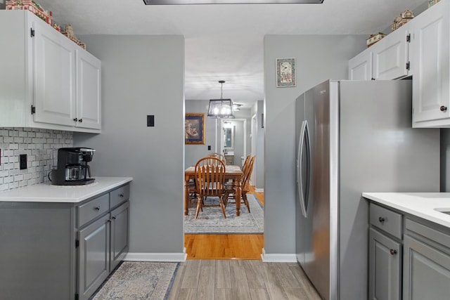 6928 Hoover Mason Ln, Mount Pleasant, TN 38474 - kitchen featuring gray cabinets, freestanding refrigerator, light wood finished floors, and decorative backsplash