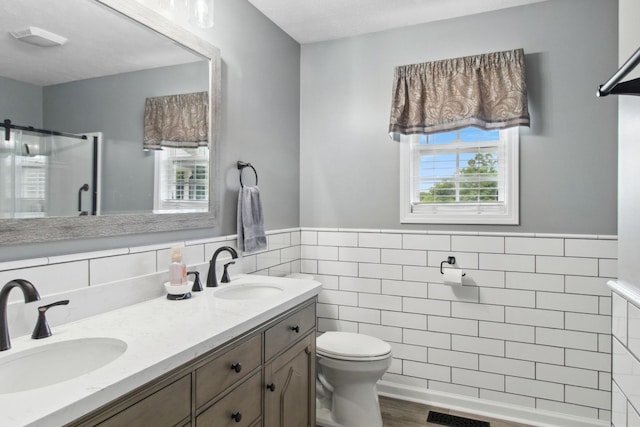 6928 Hoover Mason Ln, Mount Pleasant, TN 38474 - full bathroom with tile walls, toilet, double vanity, a shower stall, and a wainscoted wall