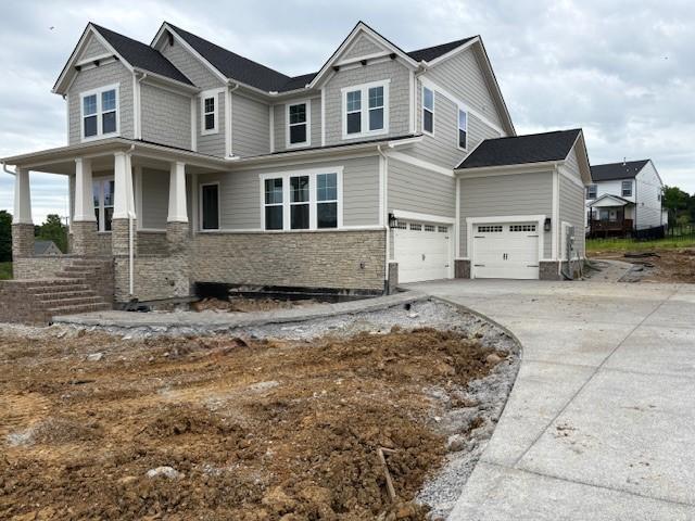 4605 Hessey Rd, Mount Juliet, TN 37122 - view of front of home with an attached garage, concrete driveway, stone siding, and covered porch