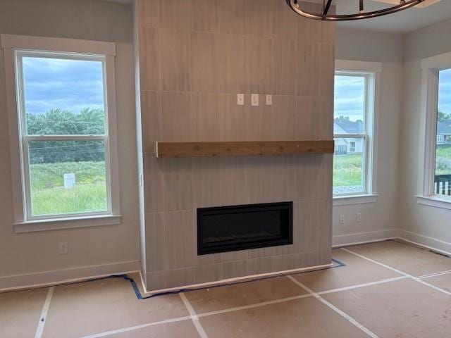4605 Hessey Rd, Mount Juliet, TN 37122 - unfurnished living room with a glass covered fireplace, baseboards, tile patterned flooring, and a chandelier