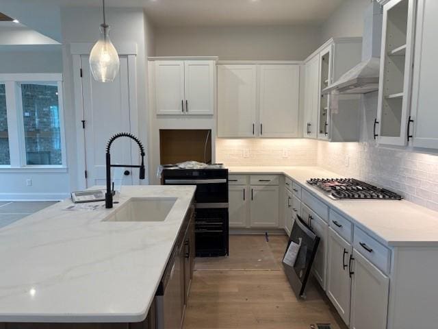 4605 Hessey Rd, Mount Juliet, TN 37122 - kitchen with stainless steel gas stovetop, wall chimney range hood, a sink, tasteful backsplash, and a kitchen island with sink