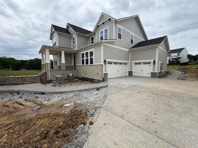 4605 Hessey Rd, Mount Juliet, TN 37122 - view of property exterior featuring a garage, stone siding, concrete driveway, and a porch