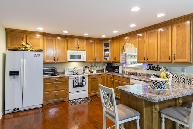 147 Crimson Dr, Winchester, TN 37398 - kitchen featuring white appliances, a sink, brown cabinets, a peninsula, and a kitchen breakfast bar