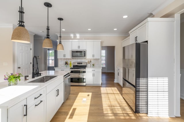 100 Nancy Ct, Hermitage, TN 37076 - kitchen featuring stainless steel appliances, a sink, light wood-style floors, ornamental molding, and tasteful backsplash