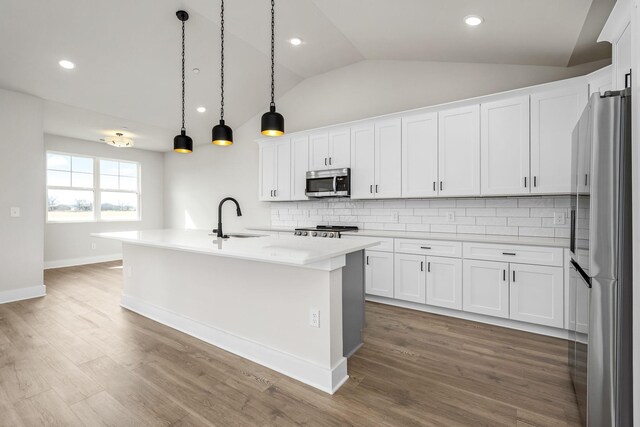 0 Stonehorn Dr, Bell Buckle, TN 37020 - kitchen featuring appliances with stainless steel finishes, vaulted ceiling, tasteful backsplash, an island with sink, and a sink