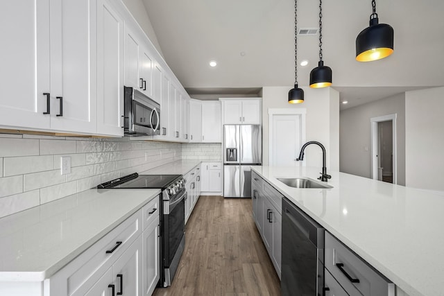 0 Stonehorn Dr, Bell Buckle, TN 37020 - kitchen featuring stainless steel appliances, a sink, light countertops, hanging light fixtures, and wood finished floors