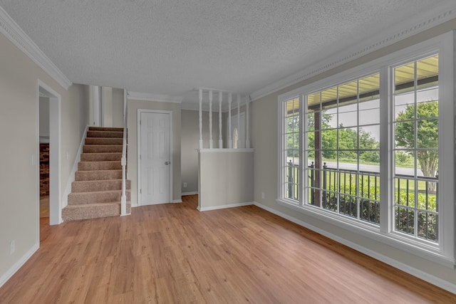 520 Almaville Rd, Smyrna, TN 37167 - unfurnished living room with ornamental molding, a textured ceiling, light wood-type flooring, baseboards, and stairs