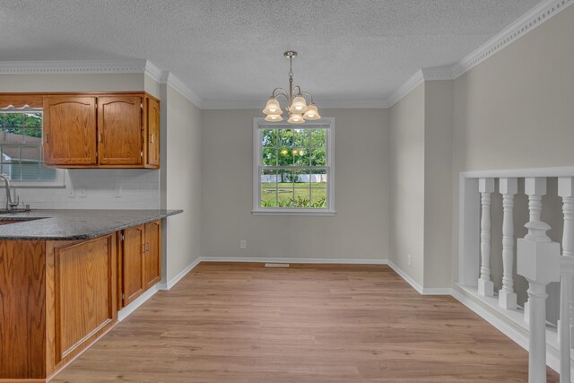 520 Almaville Rd, Smyrna, TN 37167 - kitchen with light wood finished floors, plenty of natural light, a chandelier, a sink, and a textured ceiling