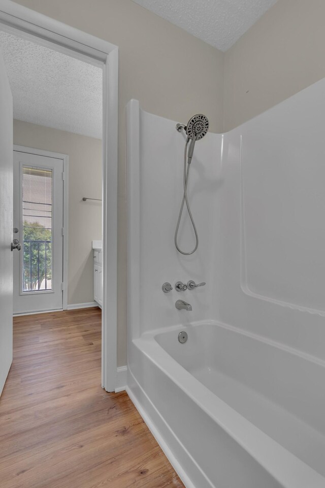 520 Almaville Rd, Smyrna, TN 37167 - full bathroom featuring a textured ceiling, wood finished floors, baseboards, and  shower combination