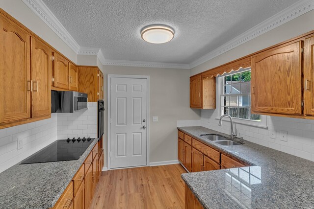 520 Almaville Rd, Smyrna, TN 37167 - kitchen with a sink, black appliances, a textured ceiling, light wood-style flooring, and brown cabinets