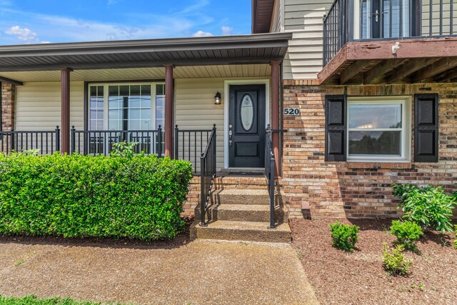 520 Almaville Rd, Smyrna, TN 37167 - view of exterior entry with brick siding, a porch, and a balcony