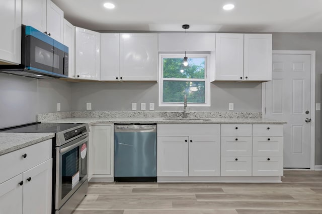 4904 Algonquin Trl, Antioch, TN 37013 - kitchen featuring stainless steel appliances, a sink, white cabinets, light stone countertops, and light wood-type flooring