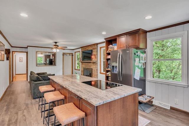 415 Isaac Dr, Goodlettsville, TN 37072 - kitchen featuring black electric stovetop, stainless steel fridge, ornamental molding, a fireplace, and a kitchen island