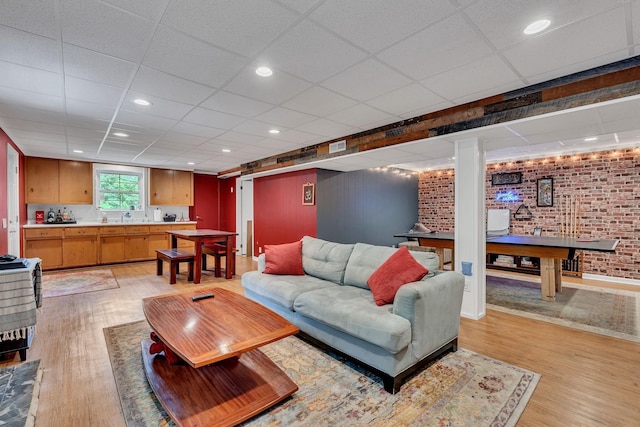 415 Isaac Dr, Goodlettsville, TN 37072 - living room with a paneled ceiling, light wood-style flooring, and brick wall