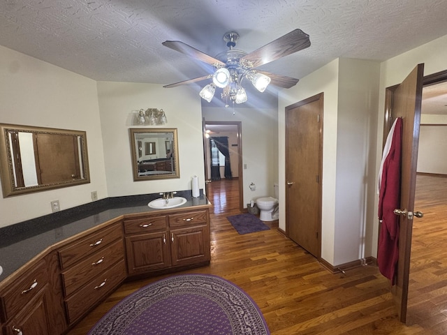 325 Lafayette Ct, Moss, TN 38575 - bathroom featuring wood finished floors, toilet, a ceiling fan, vanity, and a textured ceiling