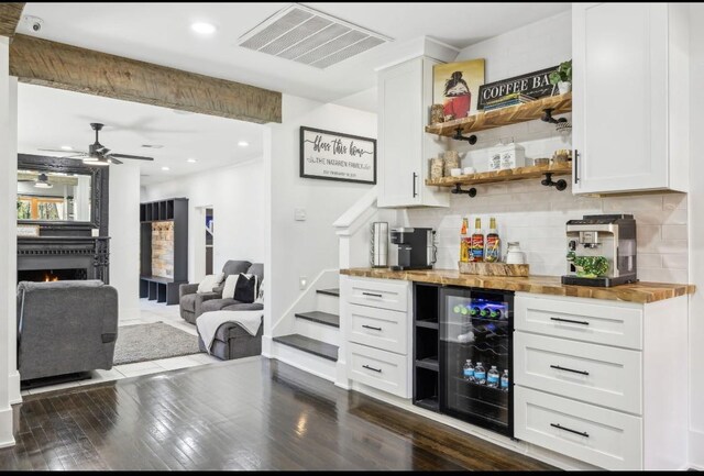 117 Park Cir, Columbia, TN 38401 - indoor dry bar featuring beverage cooler, decorative backsplash, ceiling fan, dark wood-type flooring, and a fireplace