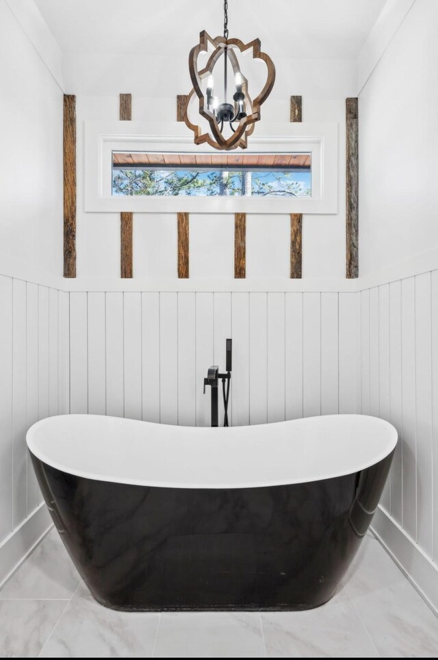 117 Park Cir, Columbia, TN 38401 - bathroom featuring a chandelier, marble finish floors, a freestanding tub, and healthy amount of natural light