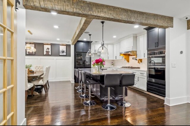 117 Park Cir, Columbia, TN 38401 - kitchen with dark wood-style flooring, appliances with stainless steel finishes, a breakfast bar, a decorative wall, and backsplash