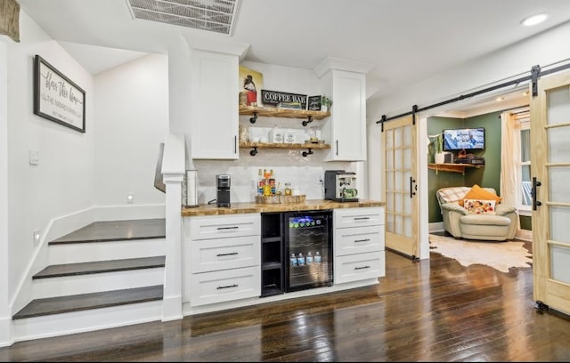 117 Park Cir, Columbia, TN 38401 - indoor dry bar featuring beverage cooler, a barn door, dark wood finished floors, tasteful backsplash, and baseboards