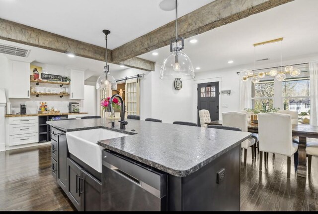 117 Park Cir, Columbia, TN 38401 - kitchen with stainless steel dishwasher, a barn door, a sink, dark wood-type flooring, and white cabinetry